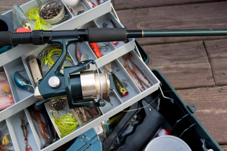 A fishermans rod reel and tackle box filled with lures and bait ready for the start of fishing season.